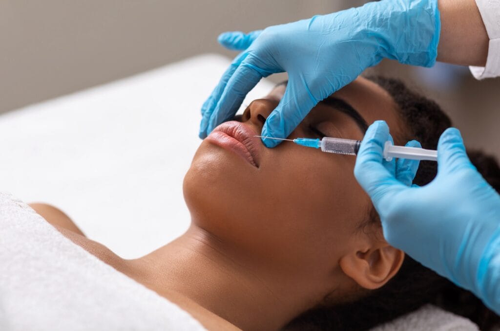 Black lady getting lip filling injection at modern beauty salon, closeup | Citidrips in Wilmington, DE